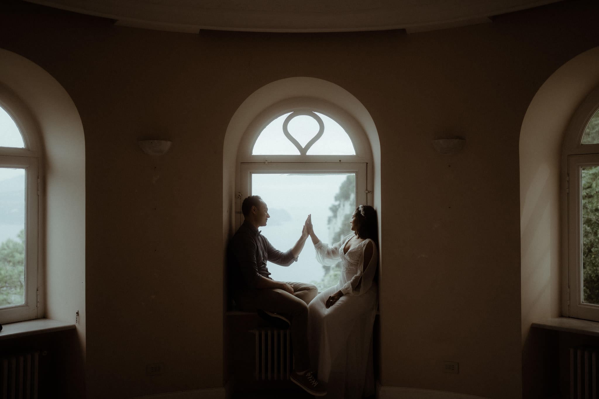 A bride and groom at a window at the Villa Lysis on their wedding and elopement day on the Island of Capri
