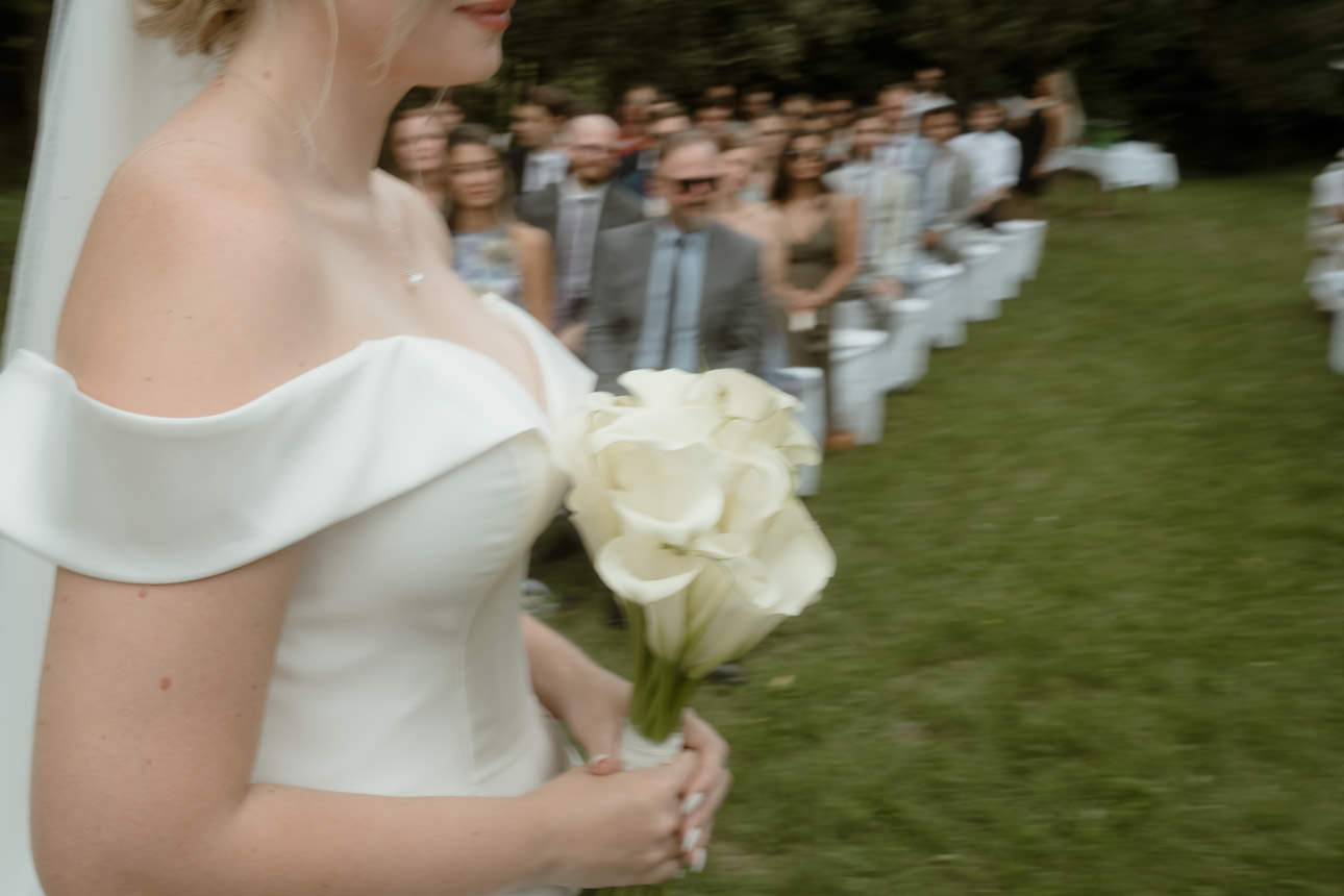 Bride standing during the wedding ceremony, holding a white bouquet near Vienna, Austria.