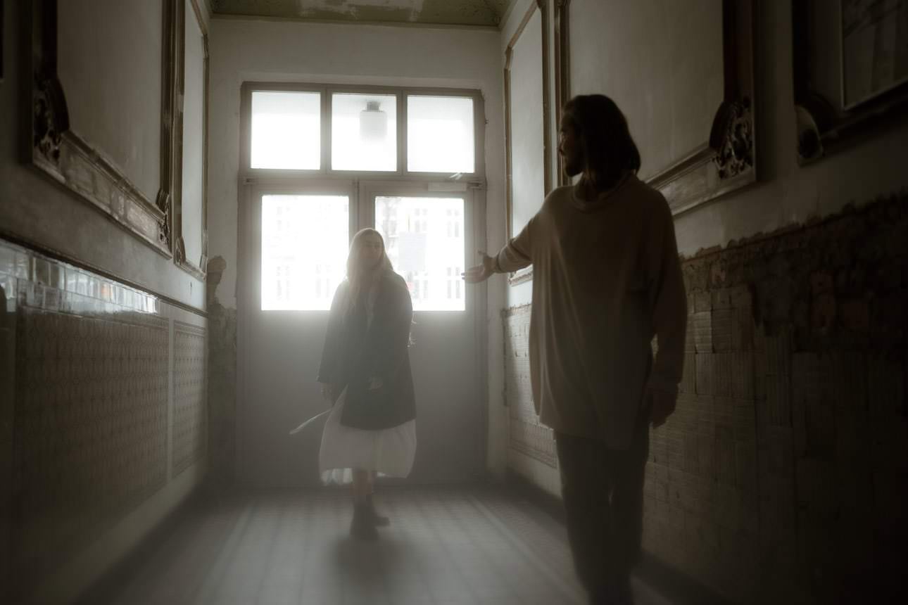 Cinematic couple photoshoot in Berlin, capturing intimate moments in an old staircase with vintage charm.