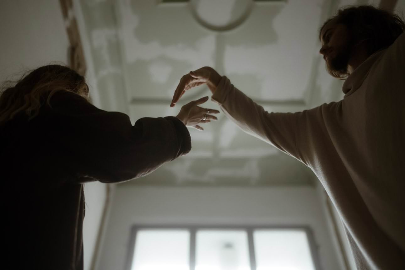 Couple playing with their hands during a photoshoot in Berlin, capturing a playful and intimate moment.