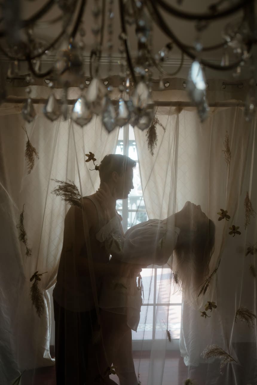 Woman leaning back in the arms of her boyfriend during a couple photoshoot in Spain, capturing a tender and intimate moment.